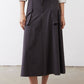 Graphite utility skirt back view, button waistband, midi length with cargo pocket panels.