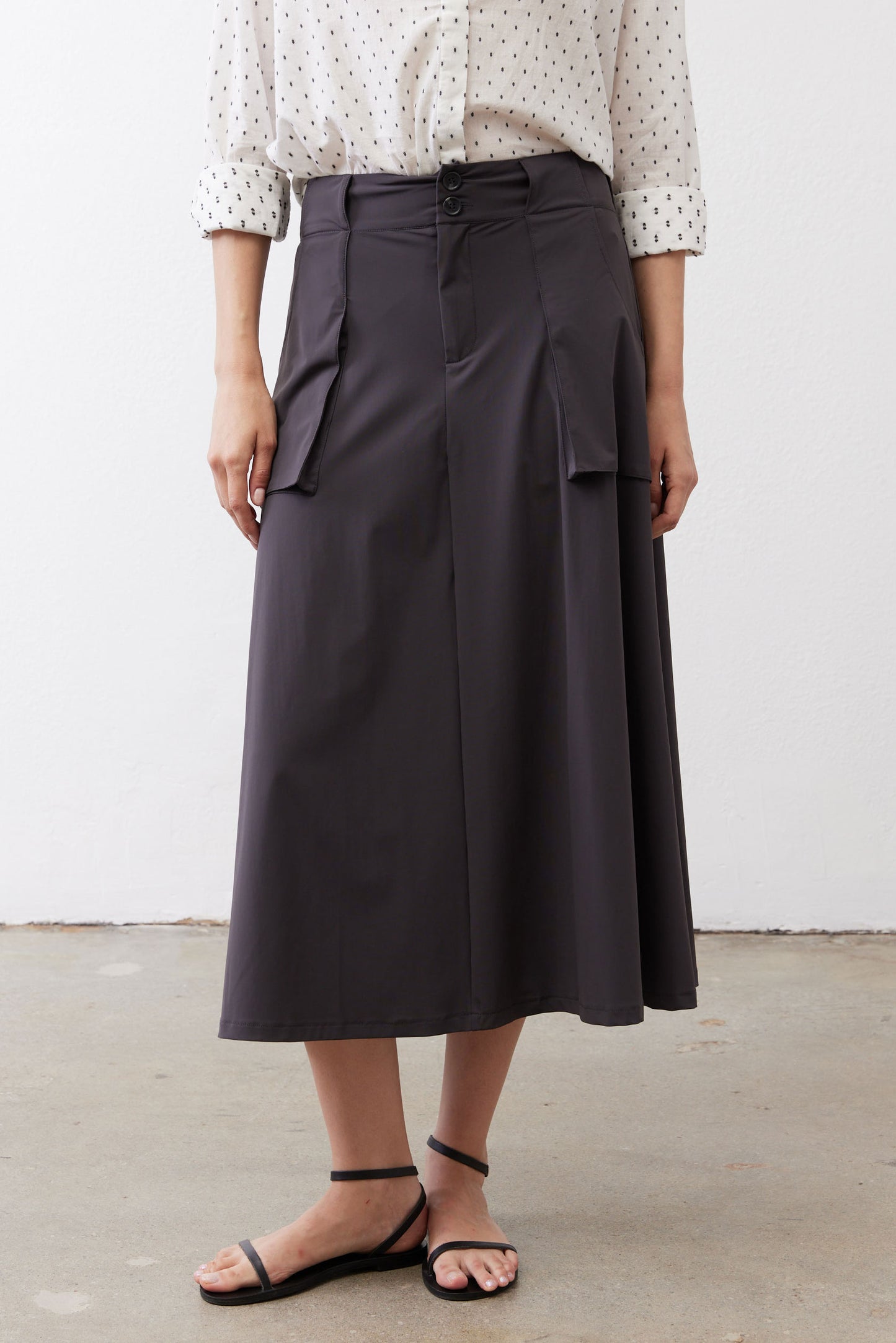 Graphite utility skirt back view, button waistband, midi length with cargo pocket panels.