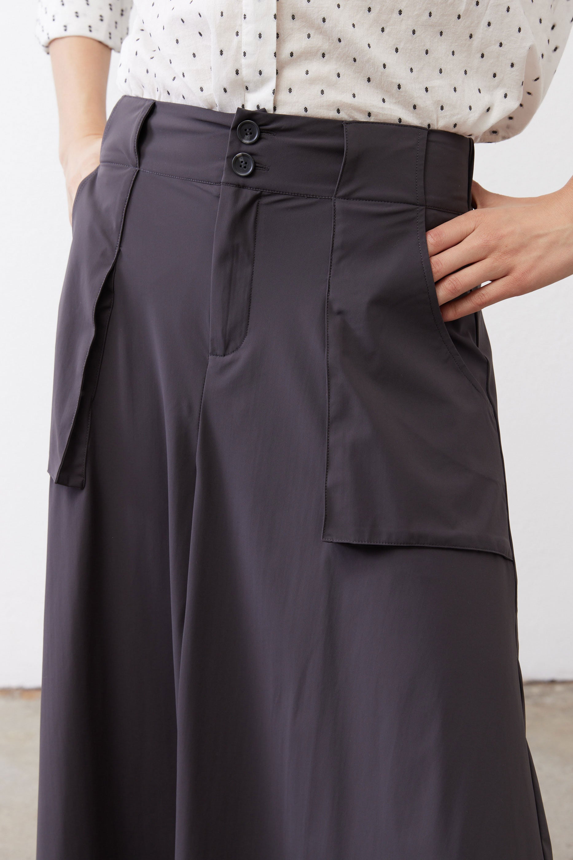Graphite utility skirt front, button closure, belt loops, cargo pocket flaps.