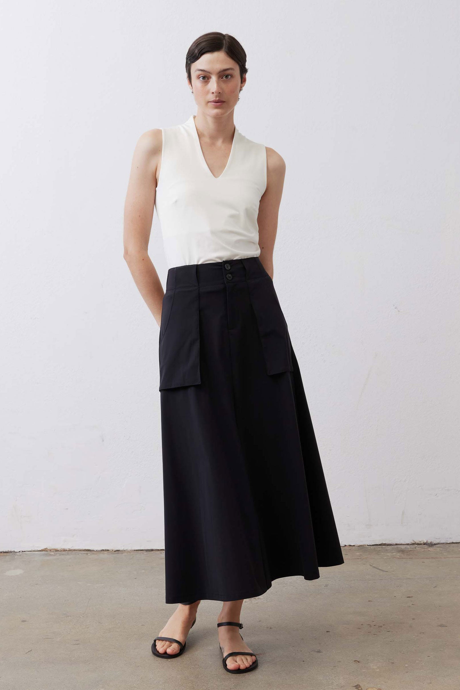 Black utility midi skirt standing view with cargo pockets and buttoned waistband