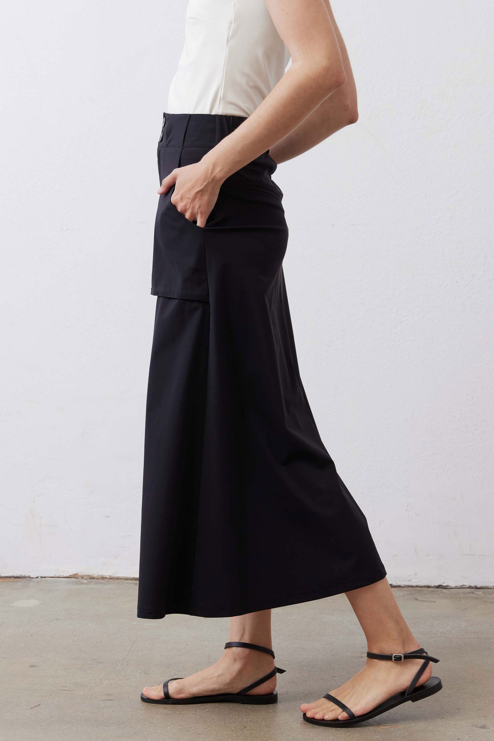 Black utility midi skirt with cargo pocket panels and front buttons, side view