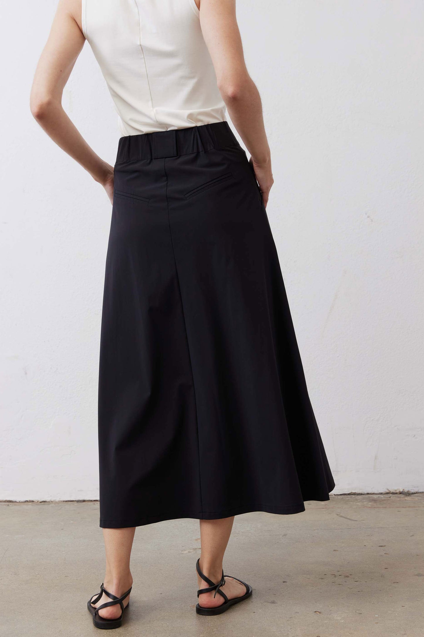 Black utility midi skirt with cargo pockets and flared hem, back view