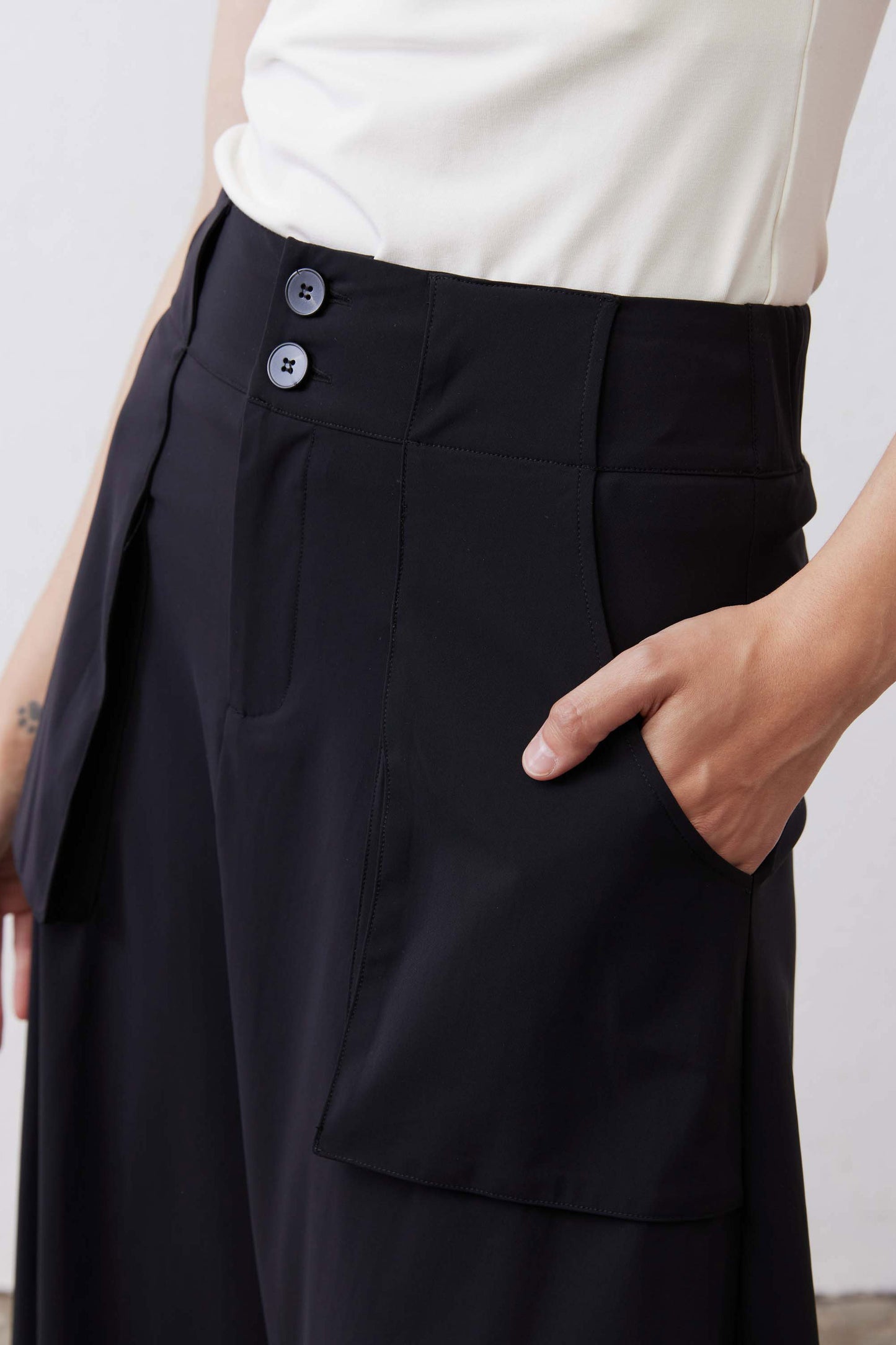 Black utility skirt close-up of button waistband and flap cargo pocket