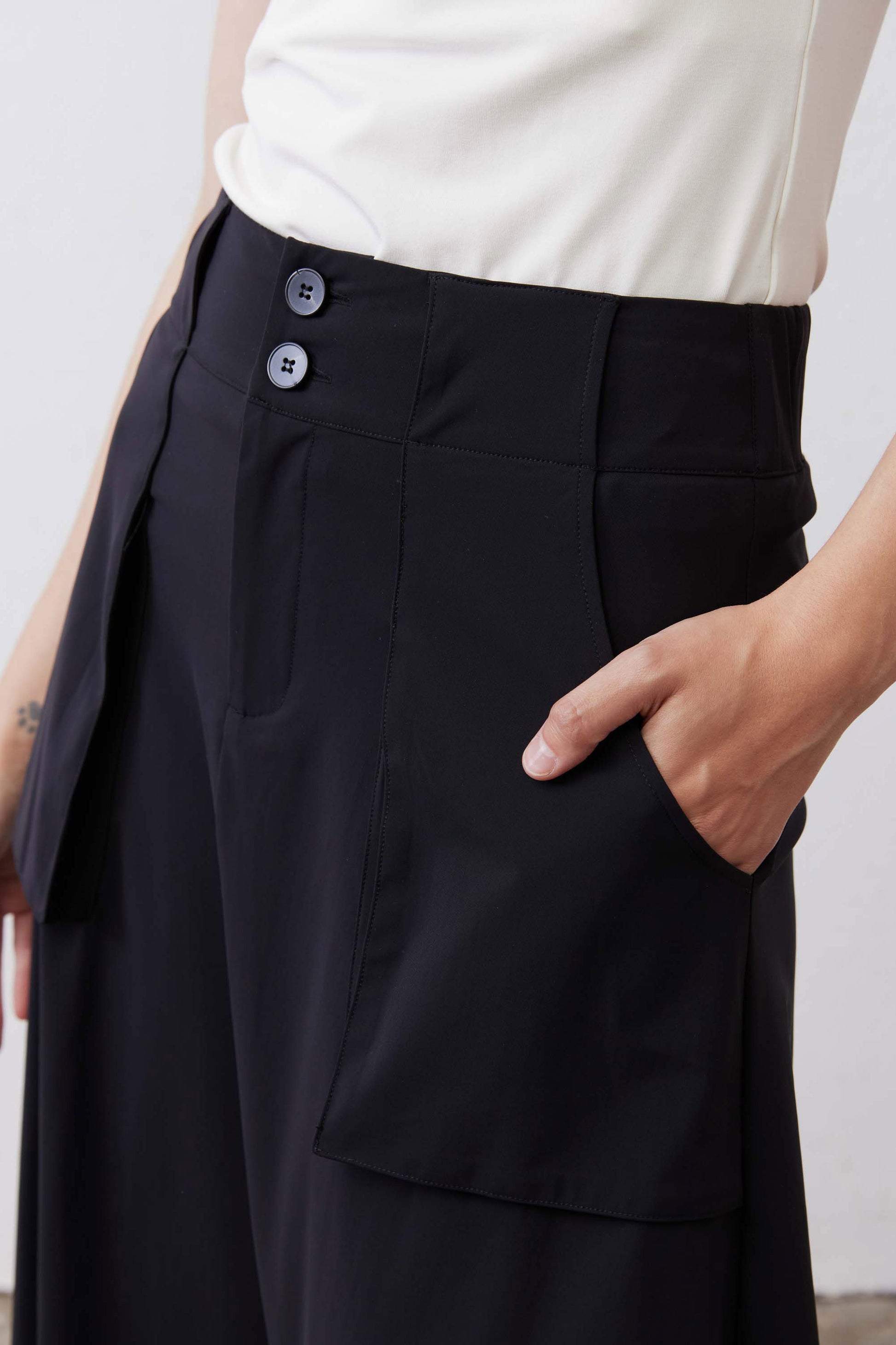 Black utility skirt close-up of button waistband and flap cargo pocket