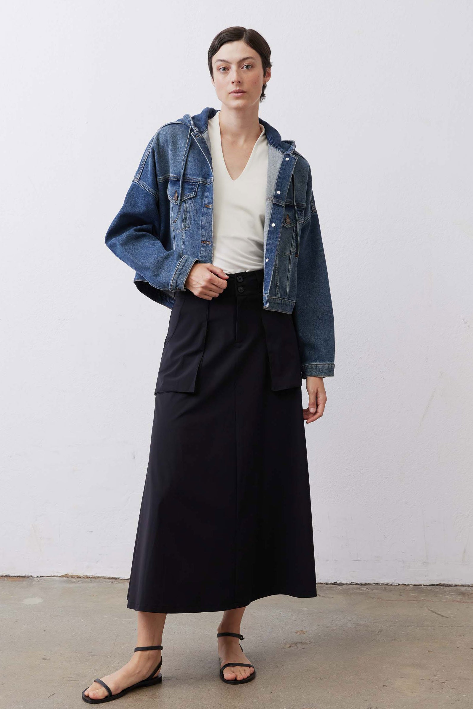 Black utility midi skirt with cargo pockets and buttoned waistband, front angle