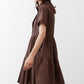 Dark brown poplin dress side view with short sleeves and tiered flared skirt