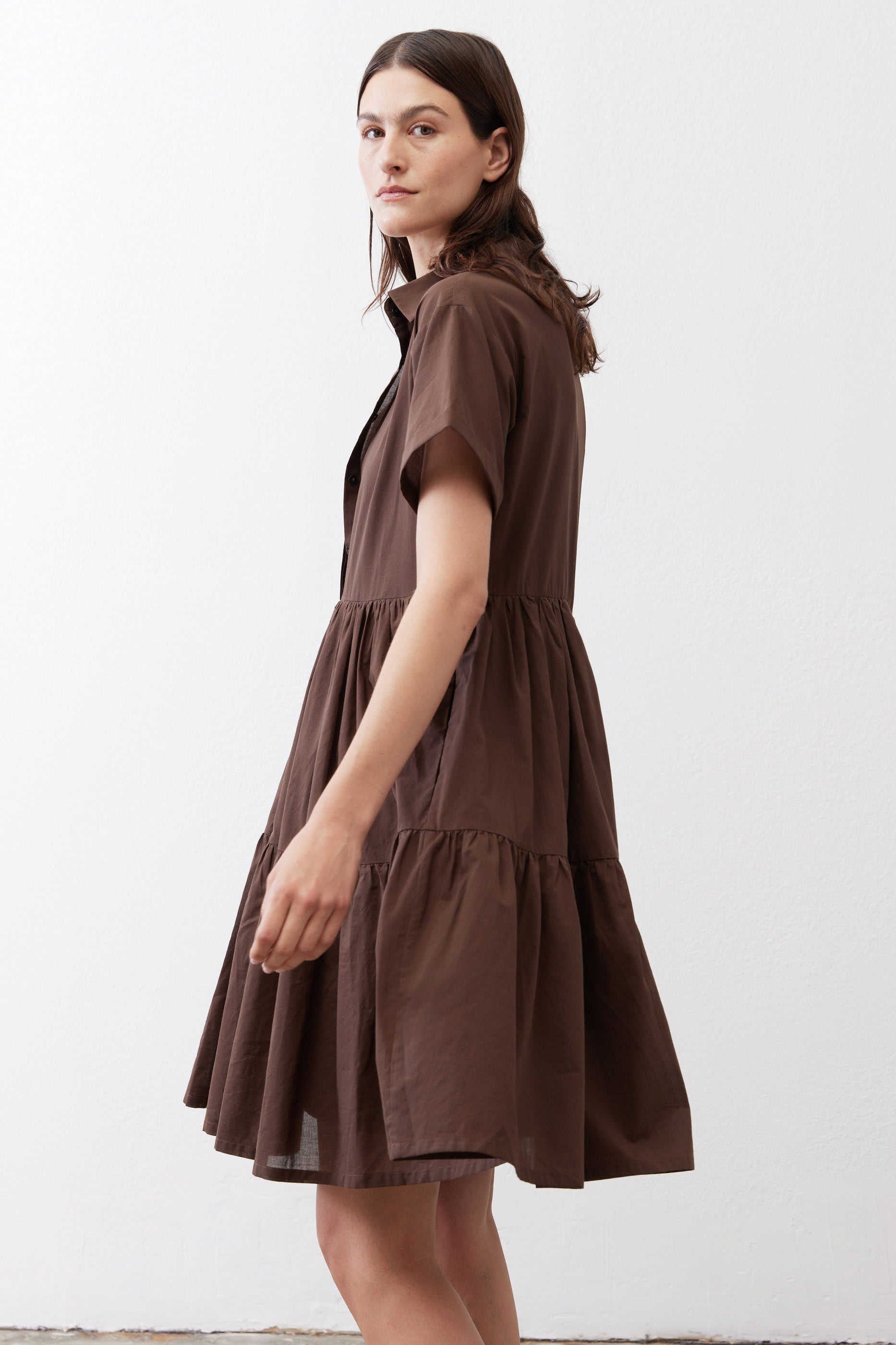 Dark brown poplin dress side view with short sleeves and tiered flared skirt