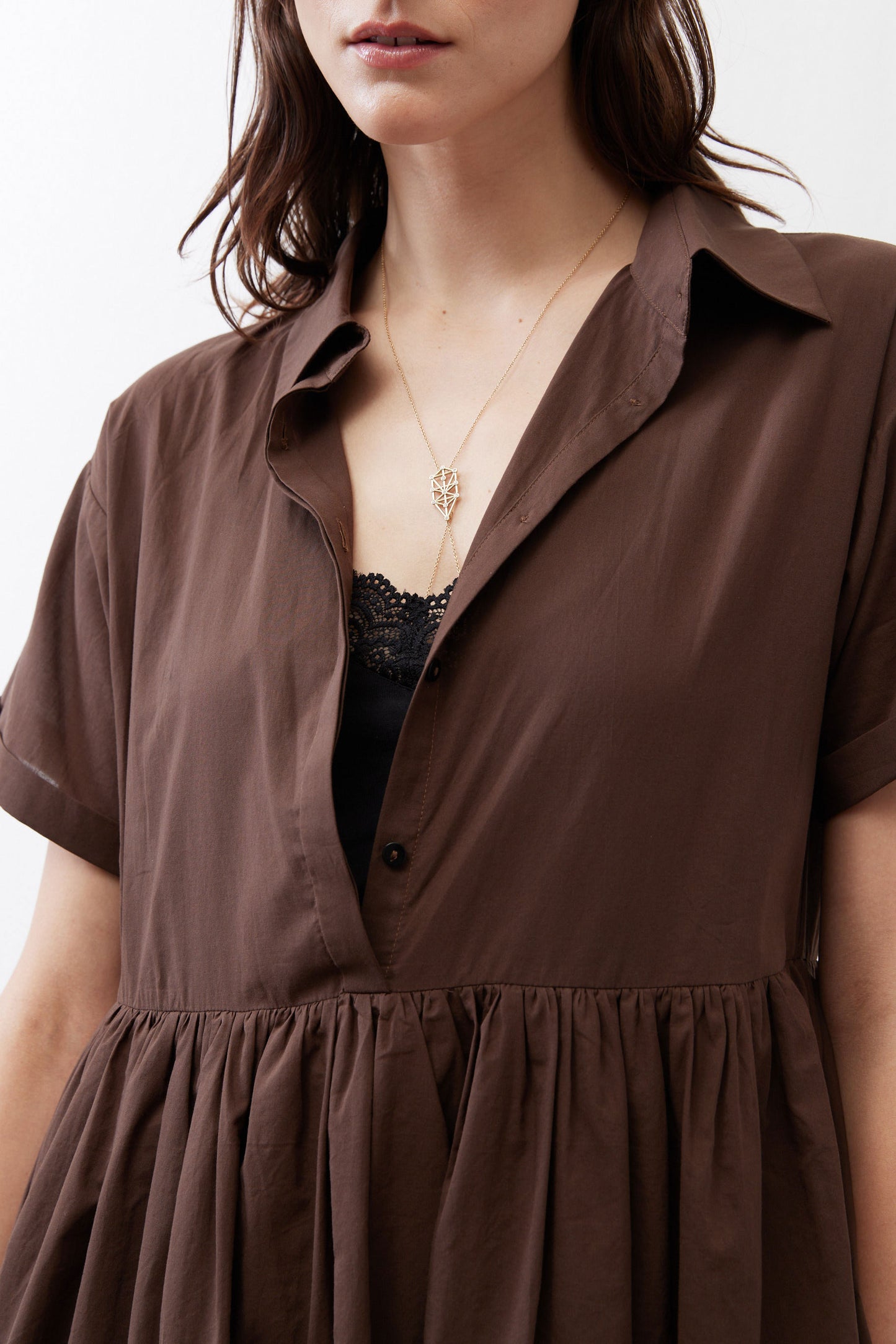 Close-up of dark brown dress: point collar, V neckline, and tiered waist