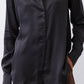 Black silk button-down top close-up: button placket, pointed collar, long sleeve