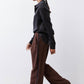 Black silk button-down top with pointed collar and button front, side view