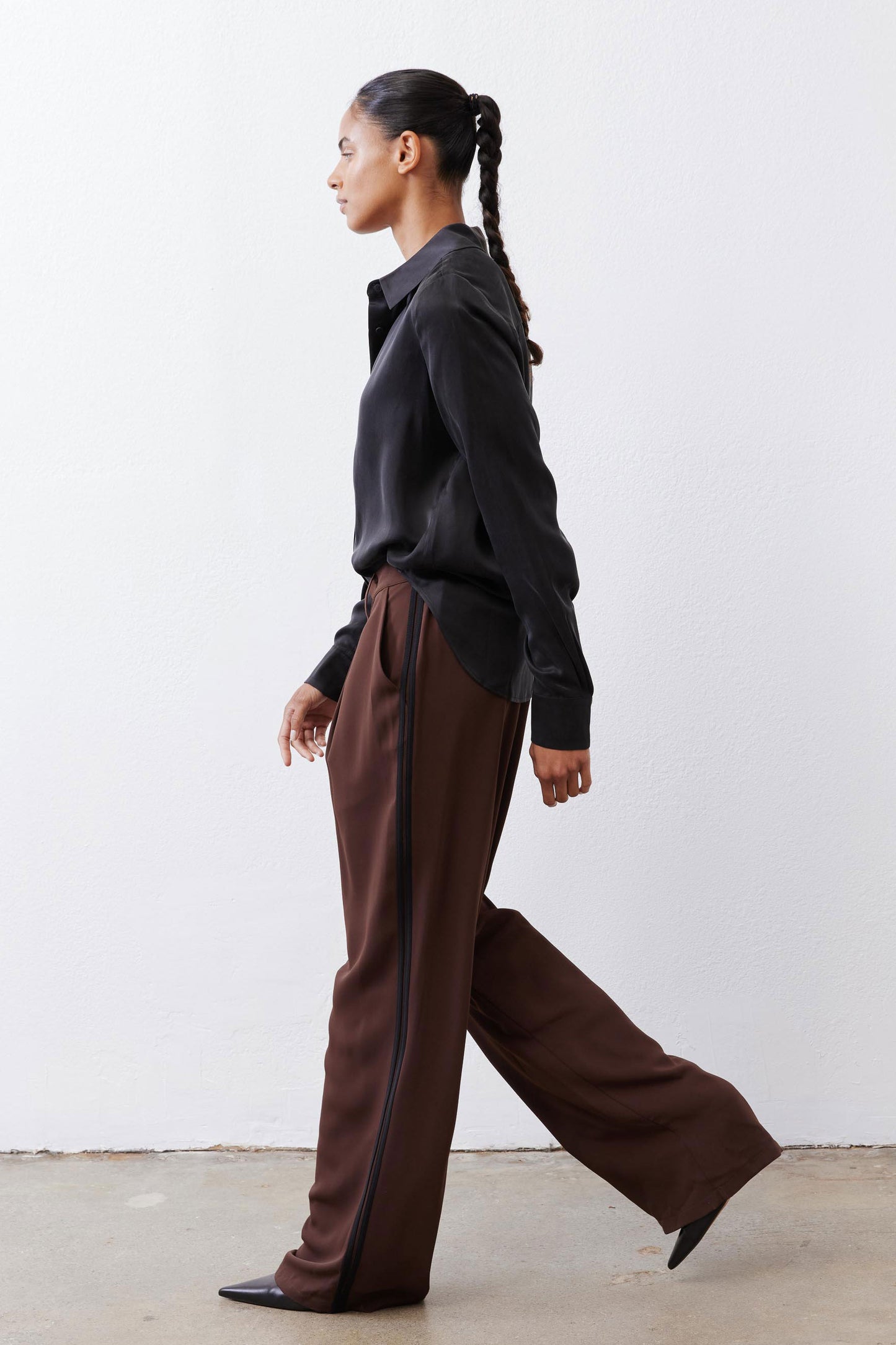Black silk button-down top with pointed collar and button front, side view