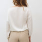 Ivory silk blouse with scoop back, long sleeves, and cinched hem