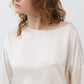 Ivory silk blouse with scoop neck and long puff sleeves; cinched hem