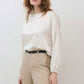 Ivory silk blouse with scoop neck and billowy long sleeves; cinched hem
