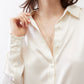 Ivory silk button-down top close-up with open collar and round front buttons