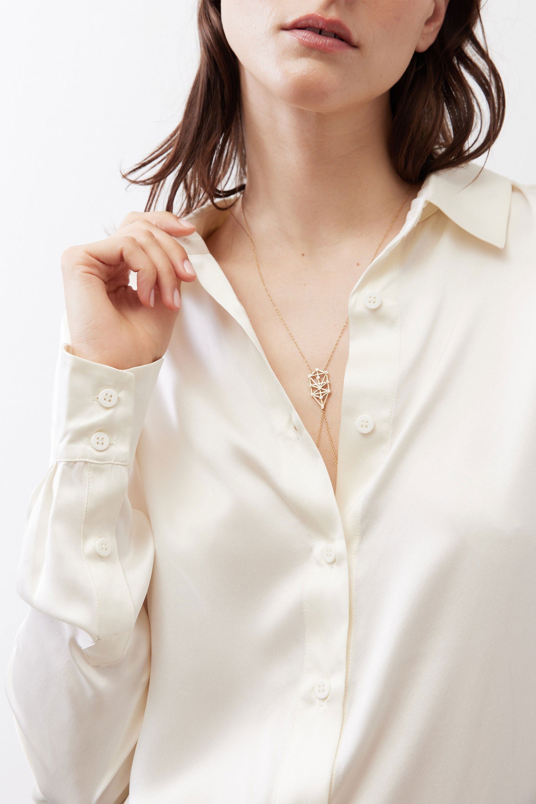 Ivory silk button-down top close-up with open collar and round front buttons