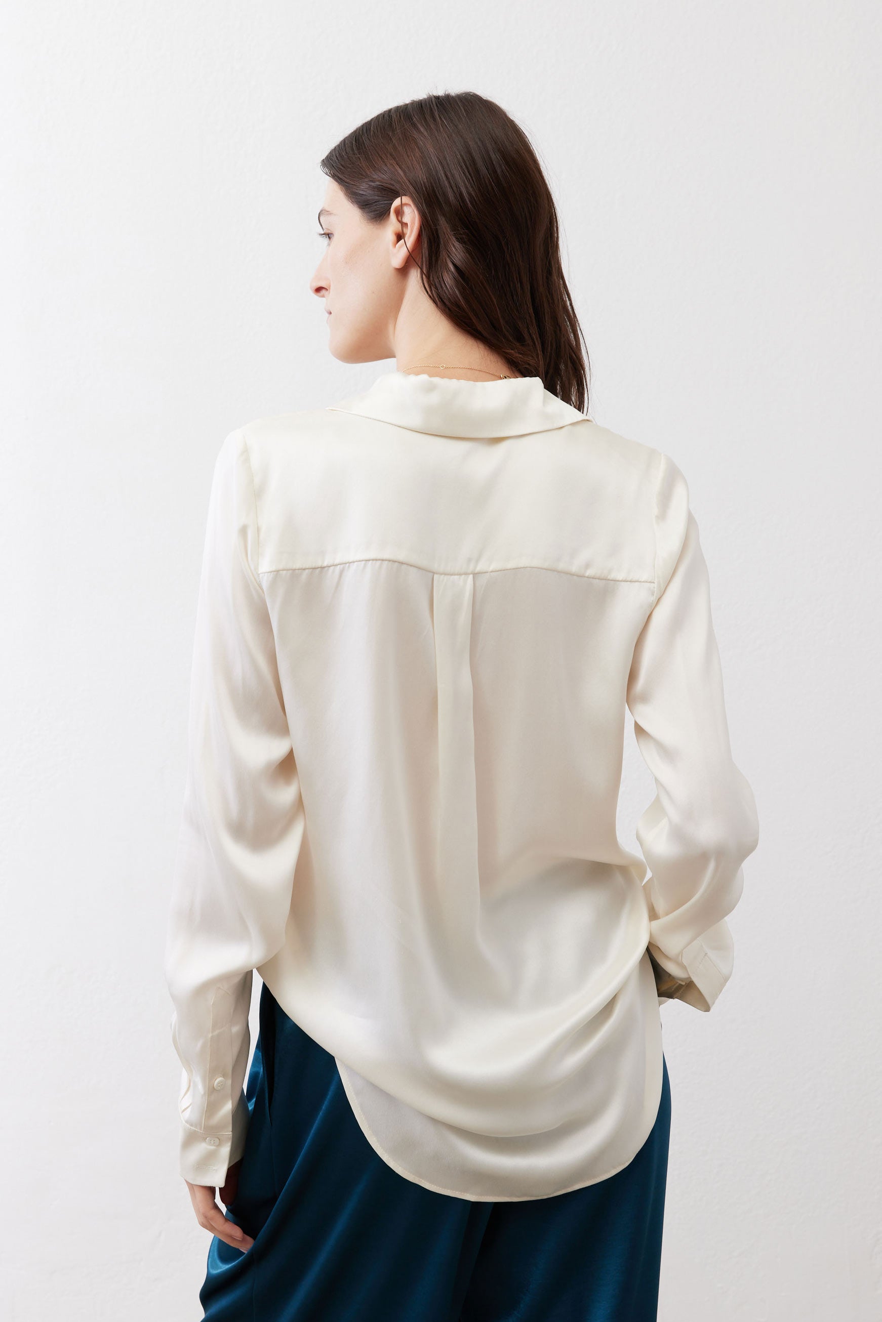 Ivory silk button-down top back view with yoke seams and long sleeves