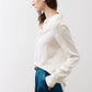 Ivory silk button-down top in side profile with buttoned cuffs