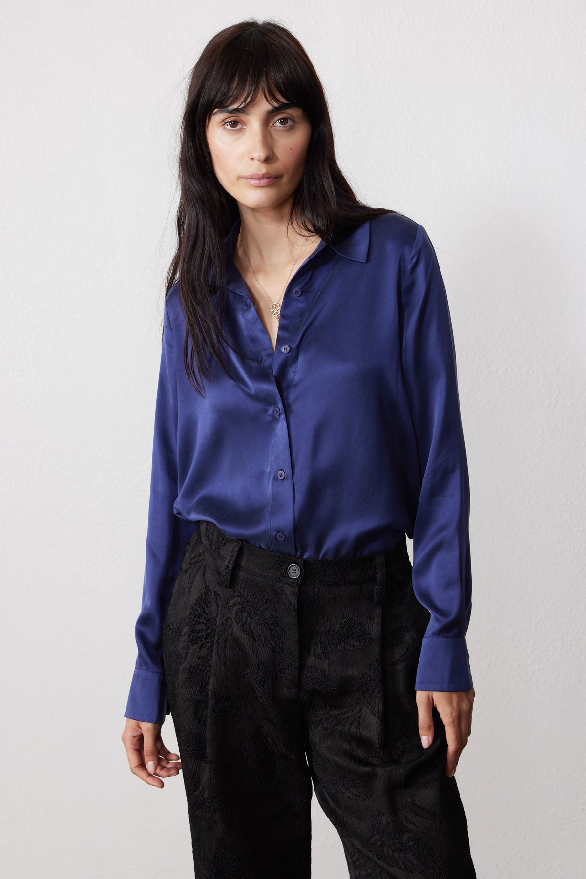 Blue silk button-down shirt with a pointed collar, front buttons, and long sleeves.
