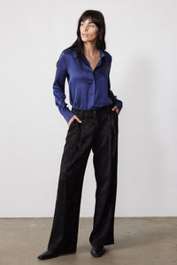 Blue washable silk button-down shirt with a pointed collar and long sleeves, shown with black pants.