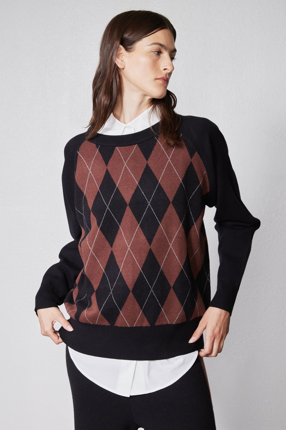 Black argyle sweater with rust diamond pattern and long sleeves, crew neck