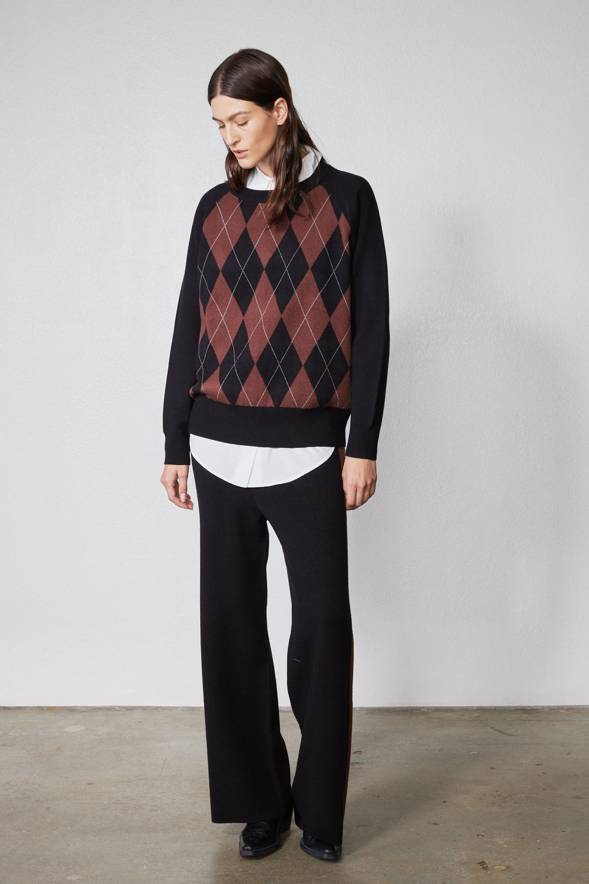 Black crewneck argyle sweater with rust diamond pattern, long sleeves