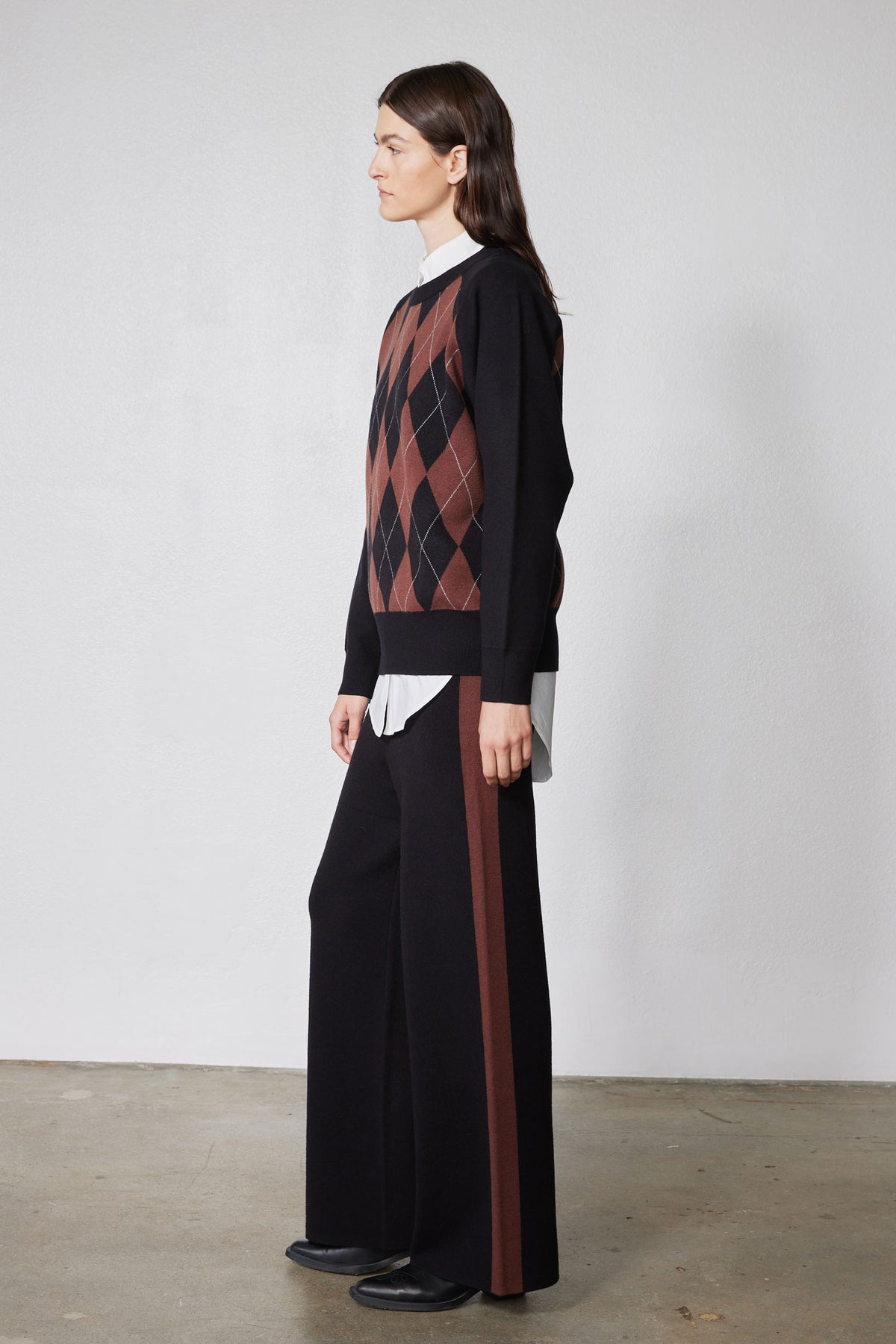 Black side-view argyle sweater with rust diamond pattern, long sleeves
