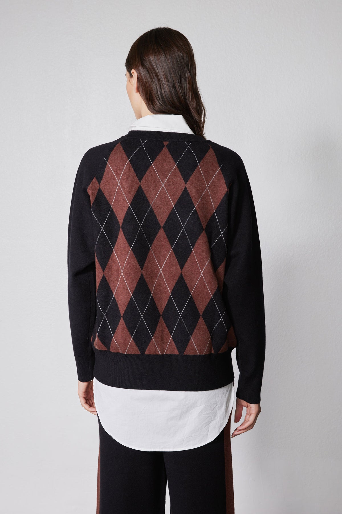 Back view of black argyle sweater with rust diamond pattern, long sleeves