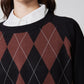 Neckline detail: black argyle sweater with rust diamond pattern and ribbed collar