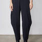 Wide-ish dark navy pants with pleated front and tapered wide legs