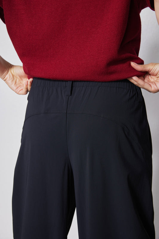 Dark navy wide pants close-up: gathered waistband with front seam details
