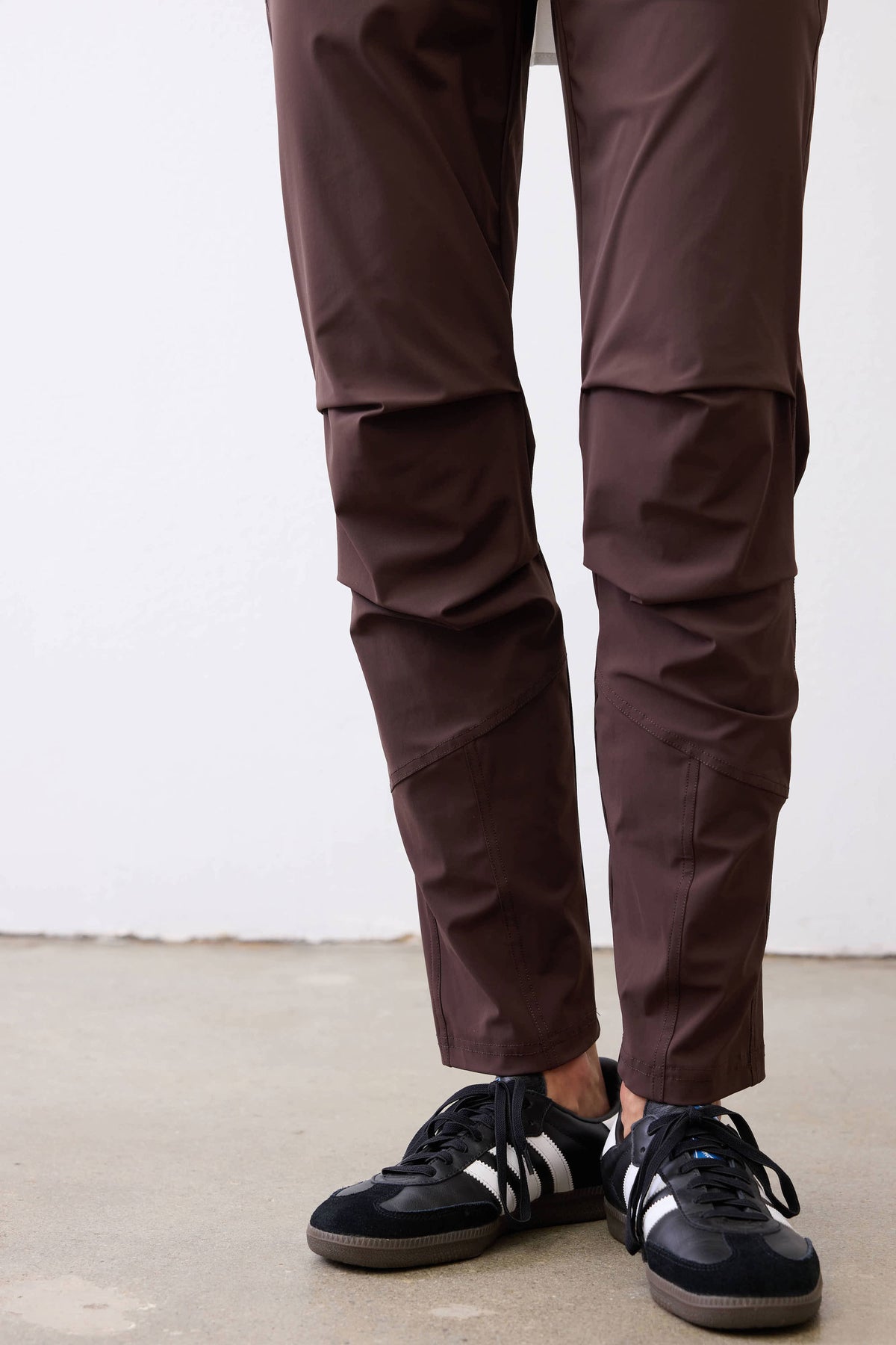 Coffee brown tapered pants with stitched knee panels and ankle seam detail