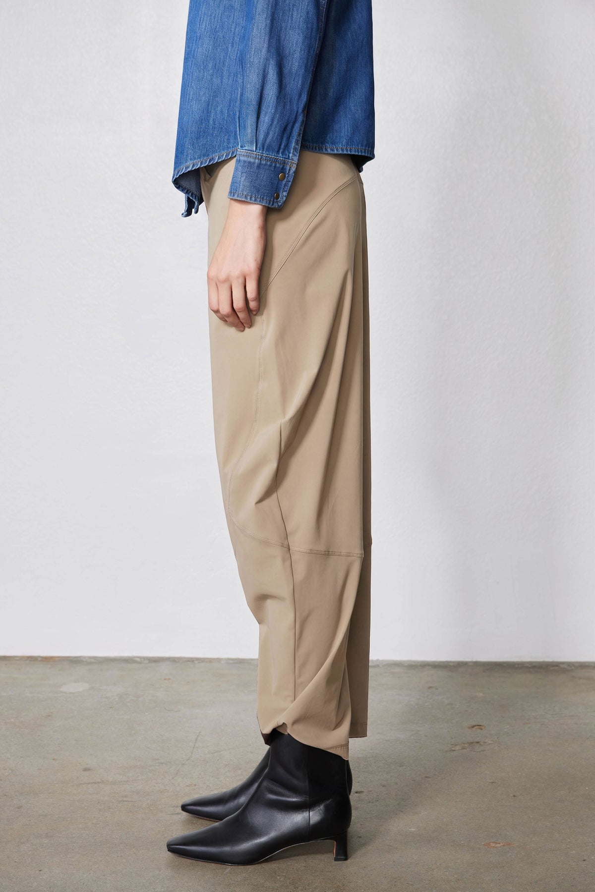 Tan wide-leg pants with elastic waistband and side pockets; side view at ankle.
