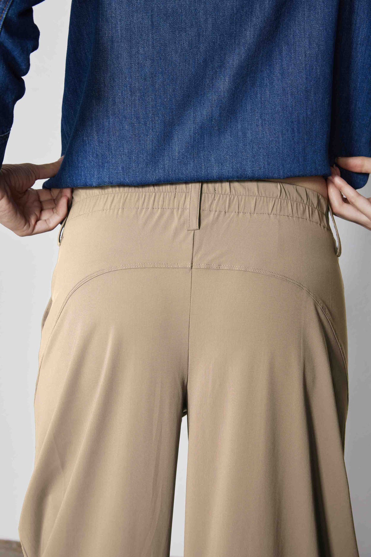 Dune-colored pants with gathered elastic waistband and side seam pockets.