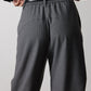Gray pinstripe suit pants detail: back waistband, belt loops, and center pleats