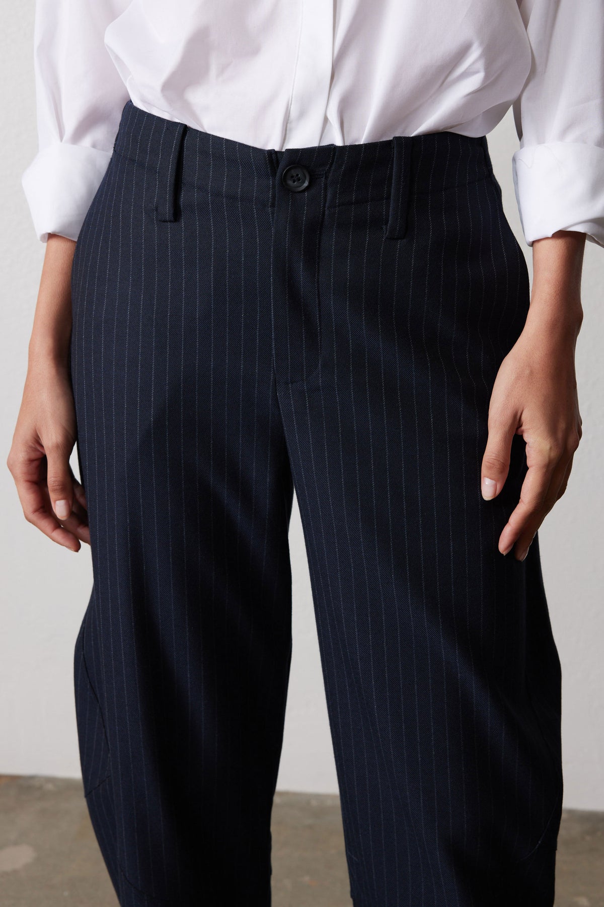 Navy gray pinstripe suit trousers, close-up of button waistband and high-rise front