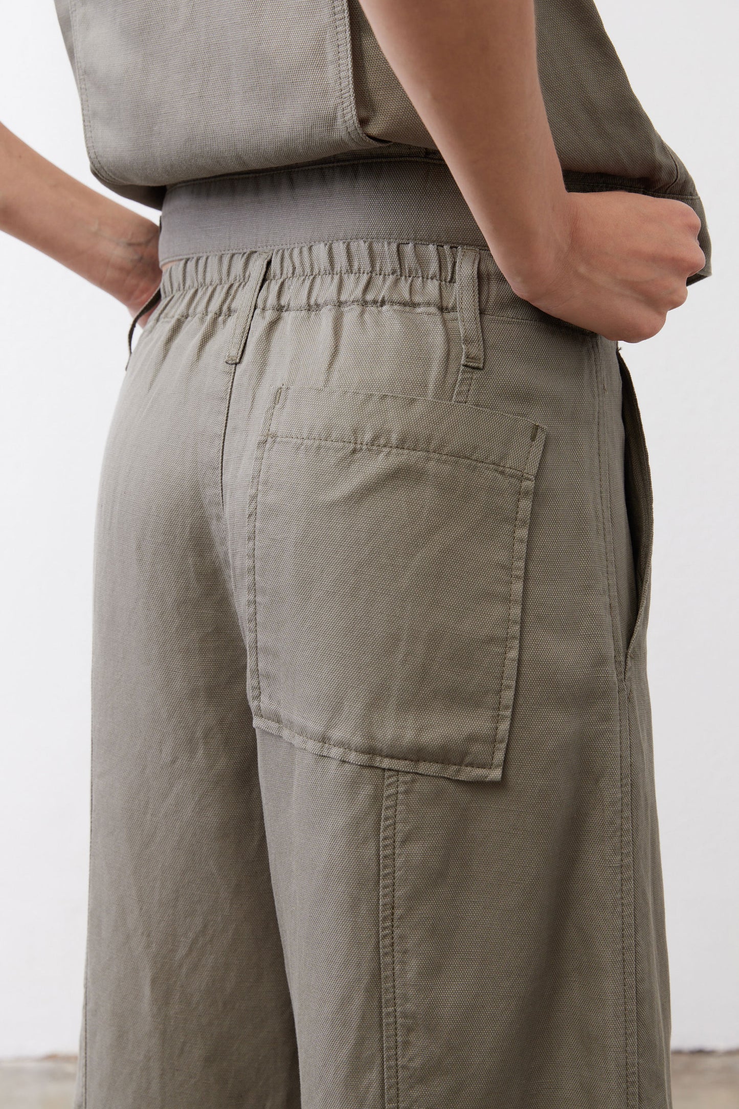 Wide-leg ankle pants in muted olive with elastic waistband and patch pockets