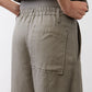 Olive pants detail: elastic waist, front patch pockets, and buttoned fly