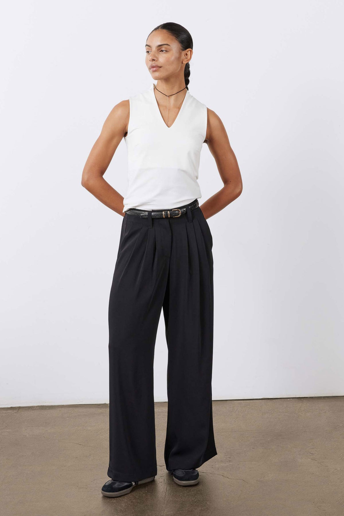 Petite black wide-leg trousers, front view, pleats and fitted waistband with belt.