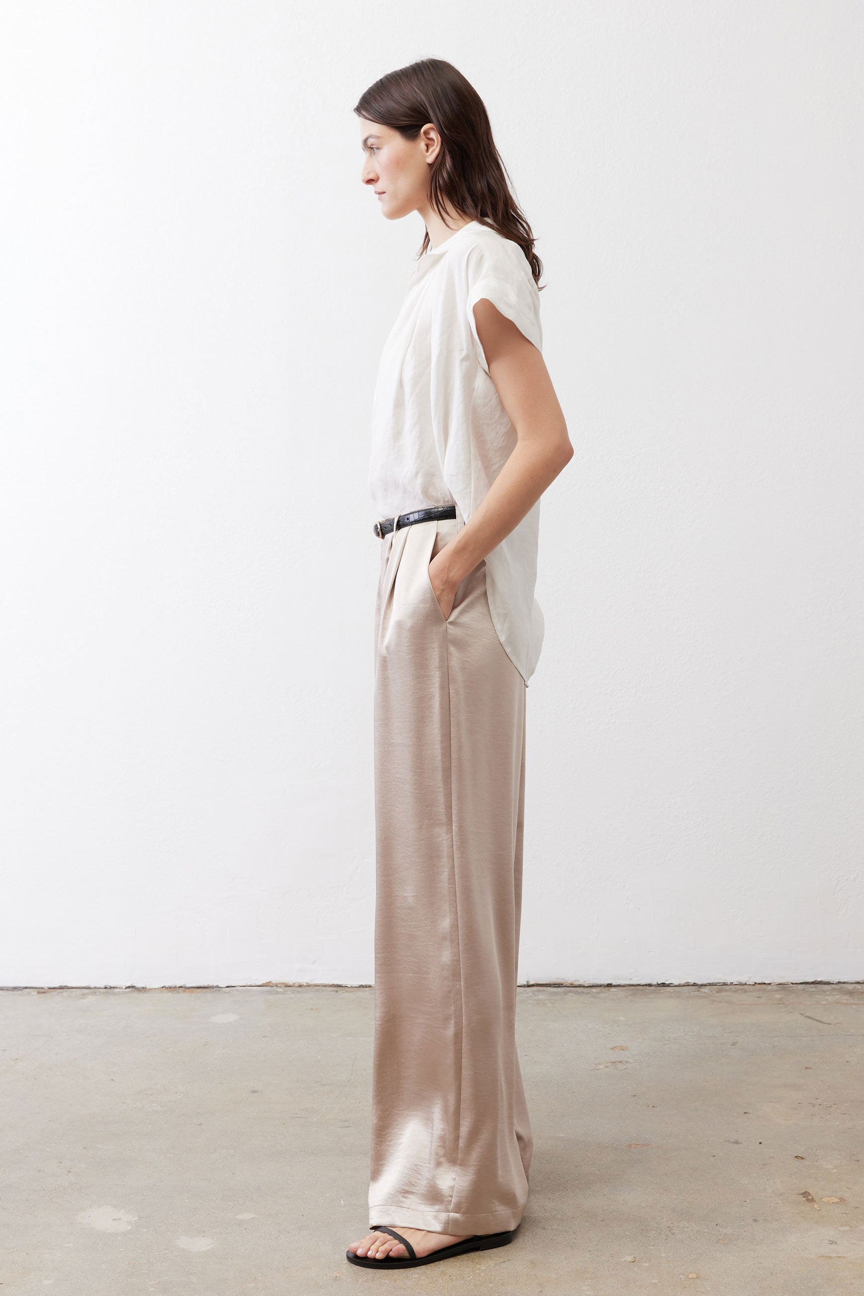 Champagne wide-leg trousers with relaxed drape, elastic waist, and black belt