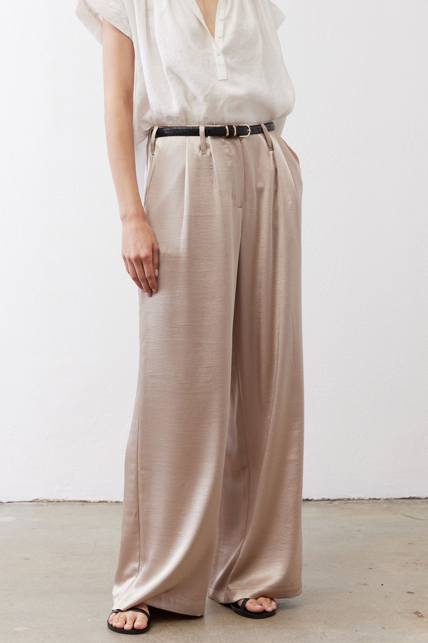 Champagne wide-leg trousers with front pleats and black belt at the waist