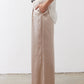 Champagne wide-leg trousers with black belt and long, wide straight legs