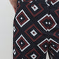Wide-leg trousers fabric close-up with diamond geometric pattern in navy and red