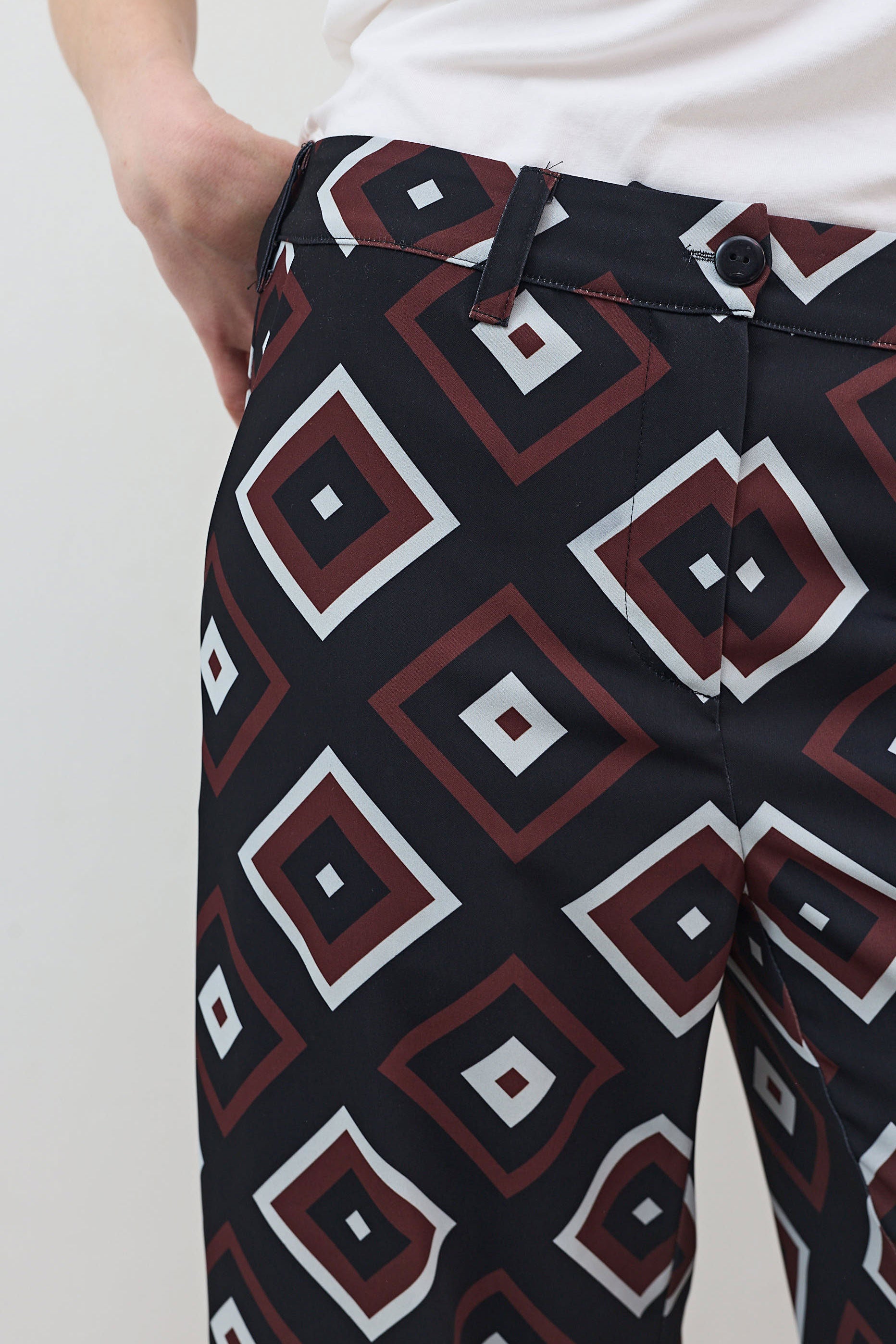Wide-leg trousers fabric close-up with diamond geometric pattern in navy and red