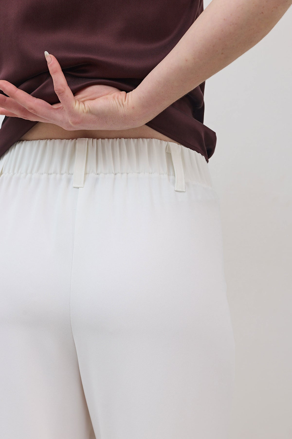 White trousers with gathered elastic waist and soft pleated panels