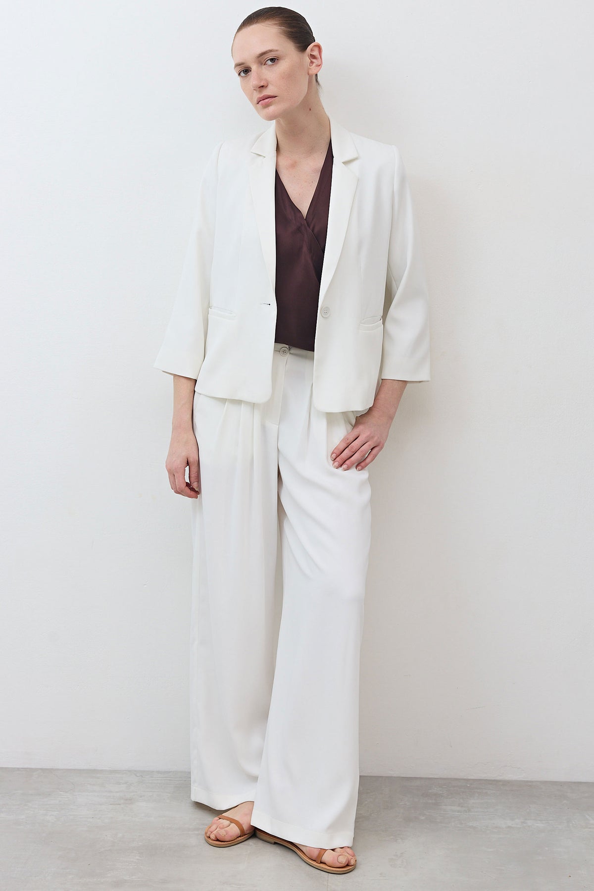 White wide-leg trousers with pleated waist and relaxed floor-length cut