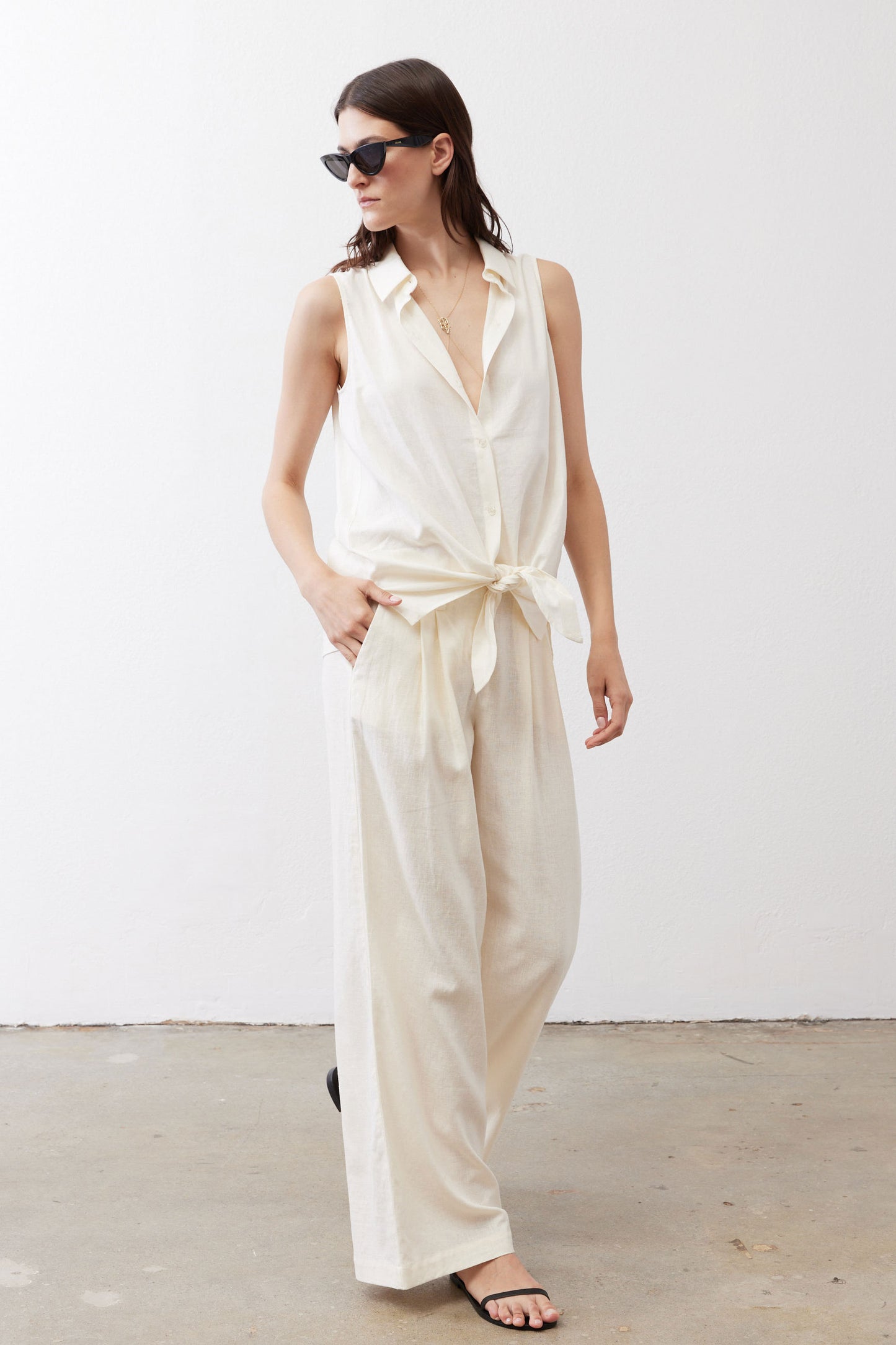 Ivory linen wide-leg trousers, side-facing front view with tied waist