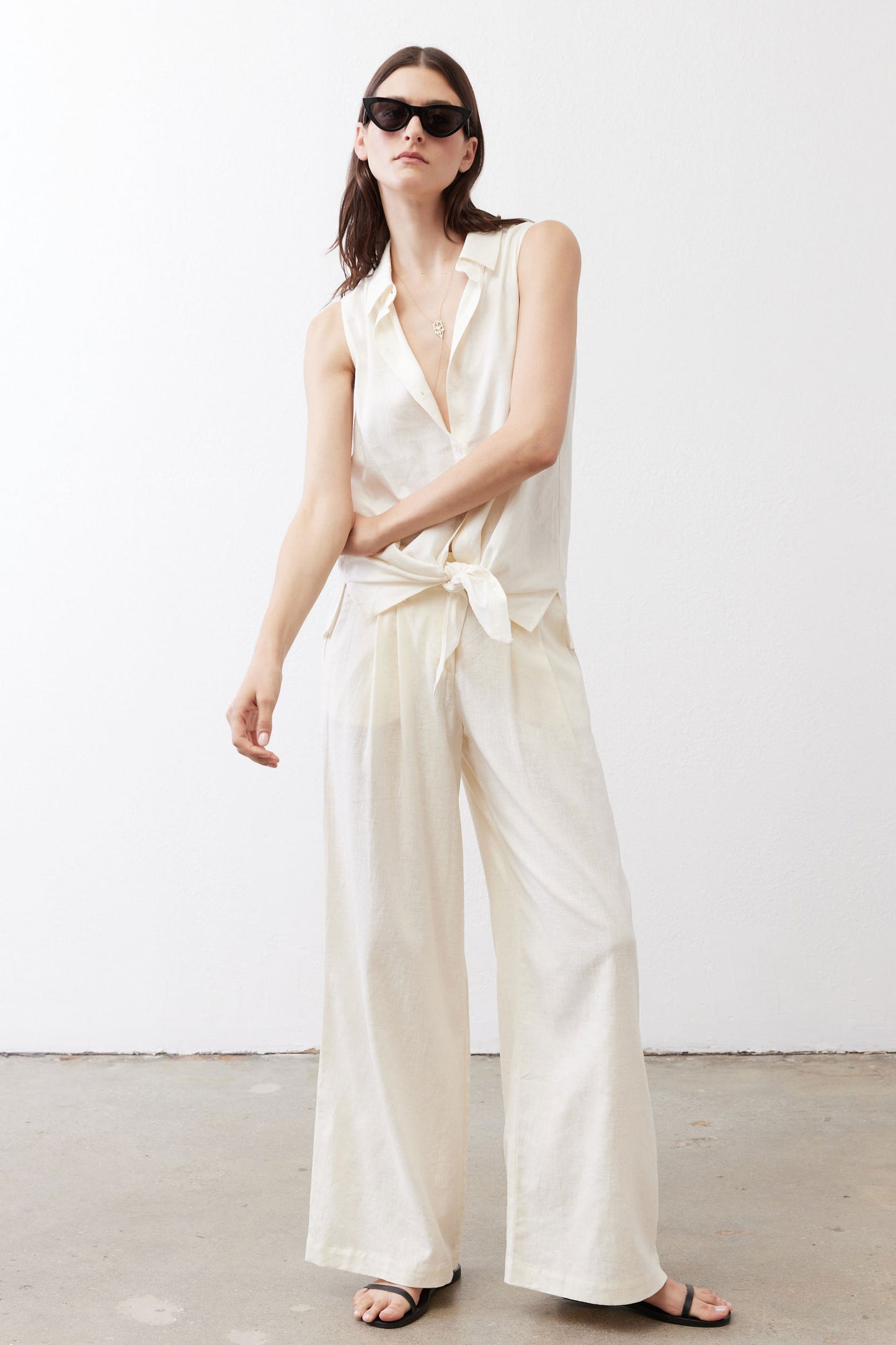 Ivory linen wide-leg trousers, angled front view with tied waist