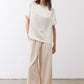 Oatmeal linen wide-leg trousers front view with drapey fabric and gathered waist