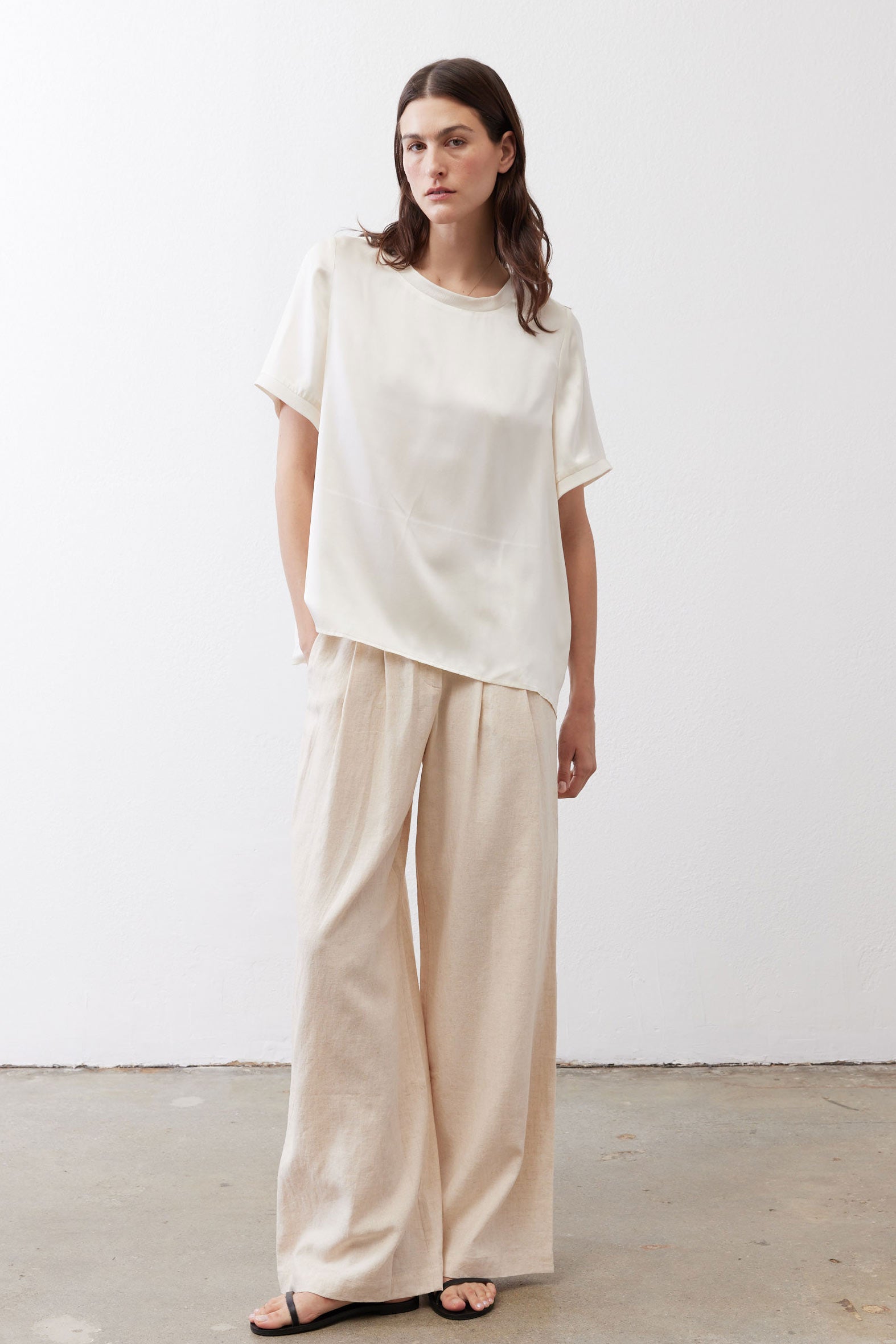 Oatmeal linen wide-leg trousers front view with drapey fabric and gathered waist